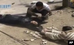 This amateur video image shot on April 24, 2011 and made available by SHAAM News Network and posted on Youtube, May 12, 2011, shows two men crawling close to the ground and dragging a woman to safety in Daraa, Syria