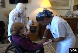 Kelli Wilson takes a patient's pulse, as nursing professor Linda Hall looks on.