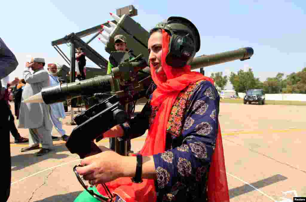 Seorang perempuan memegang senjata pada peringatan Hari Pahlawan yang juga Hari Pertahanan Pakistan di pangkalan udara Nur Khan, Islamabad.