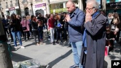 21일 프랑스 파리 시민들이 전날 총기 난사 사건이 발생한 샹젤리제 거리에서 희생자들을 애도하고 있다.