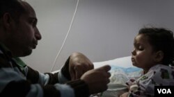 Mishaan al Abed feeds his three-year-old daughter Sarah. Sarah was among the survivors of a snowstorm that killed 16 Syrians crossing into Lebanon earlier this month.(Photo: John Owens for VOA)