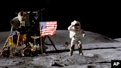 Na ovoj fotografiji iz aprila 1972. koju je NASA stavila na raspolaganje, John Young stoji pored američke zastave nakon slijetanja na Mjesec u sklopu misije Apollo 16. 