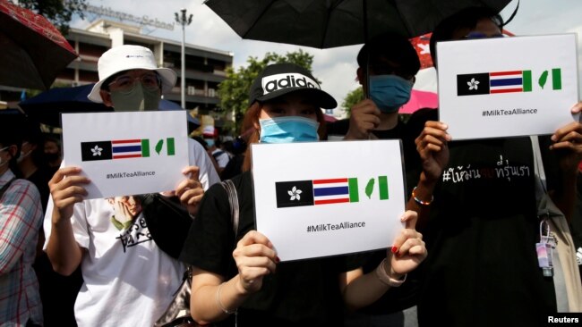 泰国抗议者们举着带有奶茶联盟标签的手牌。（2020年8月16日）