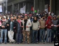 Jordanian protesters line up after pro-government supporters pelted them with stones, injuring six people during a protest at the camp in central Amman, March, 25, 2011