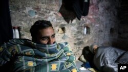 Muhammad Adeel, 24, left, and another migrant from Pakistan find shelter inside an Ottoman Gun emplacement, built on the top of a Byzantine fortification, in the northern Greek city of Thessaloniki, Jan. 14, 2018.