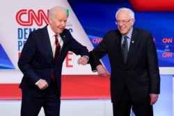 Thay vì bắt tay, hai ứng cử viên Biden và Sanders chạm khủy tay nhau trước cuộc tranh luận.