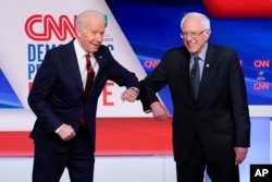 Thay vì bắt tay, hai ứng cử viên Biden và Sanders chạm khủy tay nhau trước cuộc tranh luận.