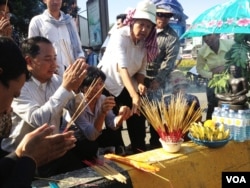 Union leader Ath Thorn (left), of the independent C.CAWDU union, joins supporters to light incense ahead of the verdict in Phnom Penh, Cambodia, May 30, 2014. (Robert Carmichael/VOA)