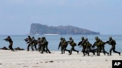 US and Philippine marines storm the beach as they simulate an amphibious landing during the joint US-Philippines military exercise dubbed Balikatan 2014, at the Naval Training Exercise Command, a former U.S. naval base, at San Antonio township, Zambales province, northwest of Manila, Philippines, May 9, 2014.
