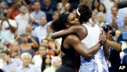 Serena Williams recibe un abrazo de su hermana Willians (de espalda) al terminar el enfrentamiento en el Abierto de Estados Unidos, ganado por la primera.