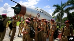 Students gather by an inactive fighter aircraft on display at a Sainik School, or military school, in Goalpara, in the northeastern Indian state of Assam, Aug. 8, 2014.