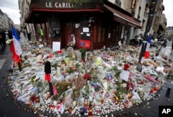 Flowers and candle tributes are placed at the Restaurant Le Carillon in Paris, Nov. 19, 2015, after last Friday's attacks.