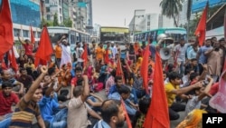 FILE - Bangladeshi garment workers and their supporters hold a rally in Dhaka, Sept. 14, 2018, to demand a higher monthly minimum wage.