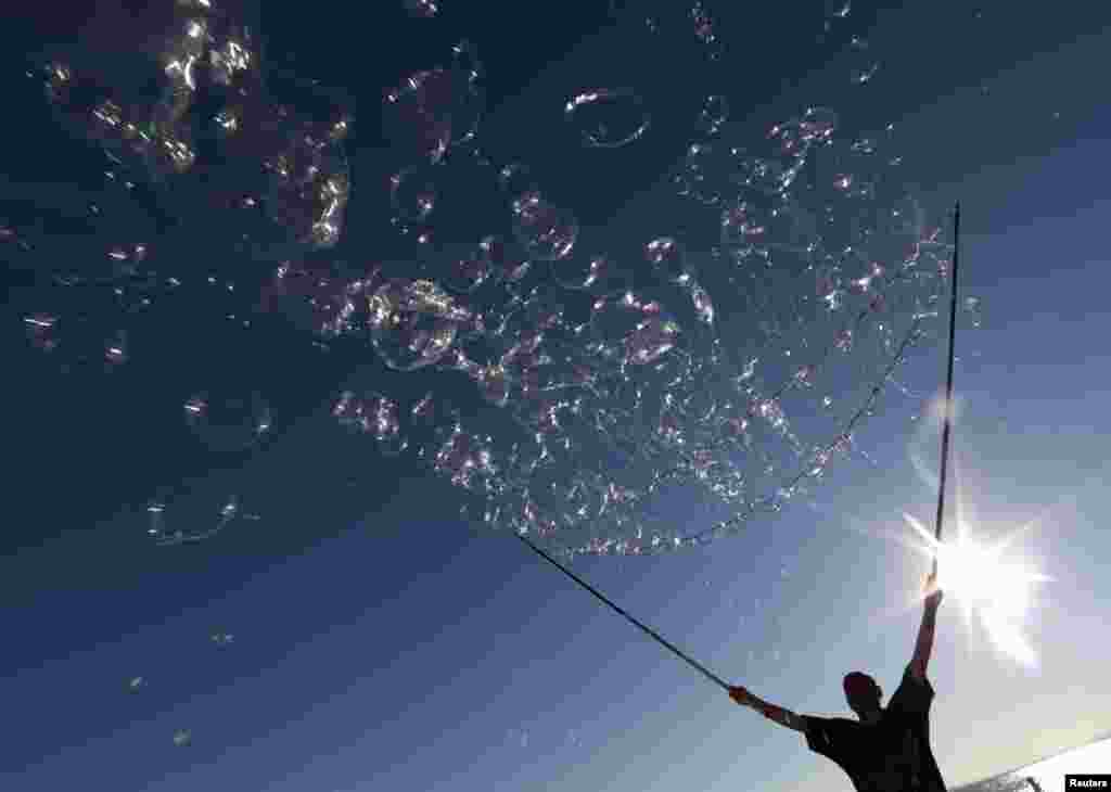 An artist performs with soap bubbles on the beach in Nice, France. 