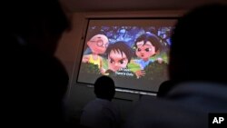 FILE - Pakistani orphans watch an early screening of the first episode of the animated "Burka Avenger" series, at an orphanage on the outskirts of Islamabad, Pakistan, March 25, 2013.