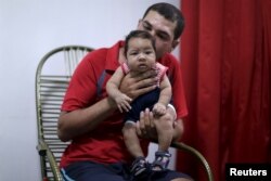Glecion Fernando holds his 2 month old son Guilherme Soares Amorim, who was born with microcephaly, near at her house in Ipojuca, Brazil, Feb. 1, 2016.