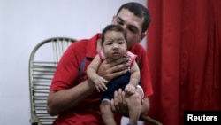 Glecion Fernando holds his 2-month-old son Guilherme Soares Amorim, who was born with microcephaly, near at her house in Ipojuca, Brazil, Feb. 1, 2016. 