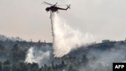 Sebuah helikopter menjatuhkan air untuk memadamkan kebakaran hutan (foto: ilustrasi). 