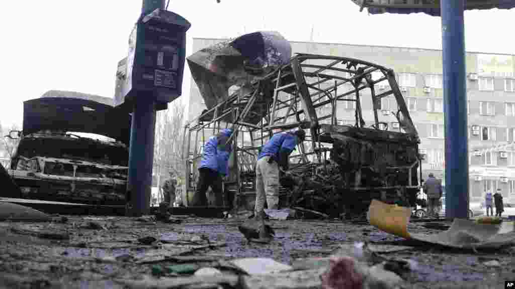 Members of Organization for Security and Co-operation in Europe (OSCE) investigate the scene after a bus station was hit during a recent shelling between Russian-backed separatists and the Ukrainian government forces in Donetsk, Feb. 11, 2015.