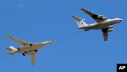 FILE - A Russian IL-78 tanker, right, demonstrating an in-flight refueling of a Tu-160 strategic bomber over Moscow in May 2014, is the type of aircraft that has used the Cam Ranh Bay base.