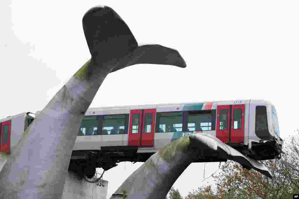 A metro is seen landed on a sculpture of a whale tail after it rammed through the end of an elevated section of rails in Spijkenisse, near Rotterdam, Netherlands.