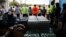 Volunteers and evacuees hold in hands while praying before serving dinner at a makeshift donation center Tuesday, May 8, 2018, in Pahoa, Hawaii. 
