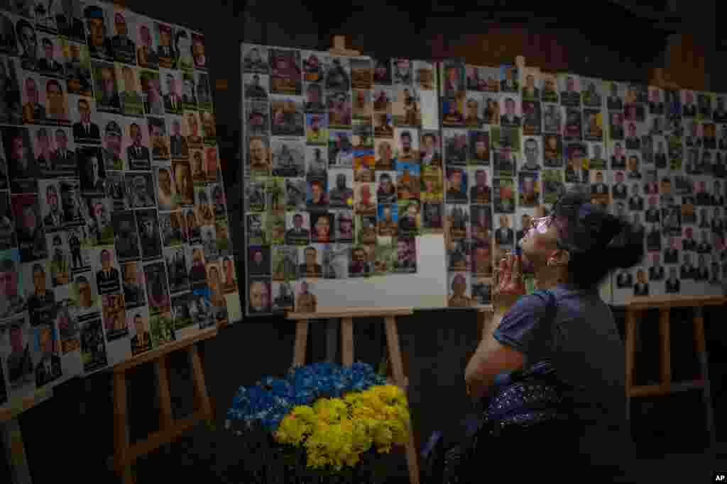 Ukrainian Lyubov weeps as she prays in front of portraits of war dead servicemen in a church in Lviv, Ukraine.