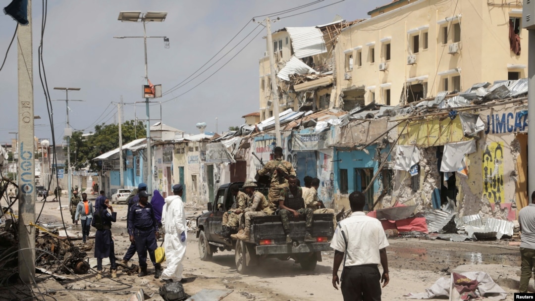 Police and military officials comb the scene of an al-Qaida-linked al-Shabab group militant attack, in Mogadishu, Aug. 21, 2022.