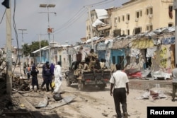 FILE - Police and military officials comb the scene of an al Qaeda-linked al-Shabaab group militant attack in Mogadishu, Aug. 21, 2022.
