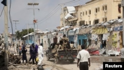 Police and military officials comb the scene of an al Qaeda-linked al-Shabab group militant attack, in Mogadishu, Aug. 21, 2022.