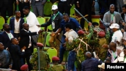 Las personas se involucran en una pelea con los funcionarios de seguridad mientras impiden que el presidente de la IEBC haga un anuncio de los resultados de las elecciones en el Centro Nacional de Escrutinio de la IEBC en Bomas of Kenya, en Nairobi, Kenia