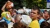 Local residents, many of whom fled the war, gather to hand out donated items such as medicines, clothes, and personal belongings to their relatives on the territories occupied by Russia, in Zaporizhzhia, Ukraine, Aug. 14, 2022. 