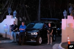 Agen Dinas Rahasia Bersenjata berdiri di luar pintu masuk ke kediaman pribadi mantan Presiden Donald Trump di Mar-a-Lago, Palm Beach, Florida Senin malam, 8 Agustus 2022.
