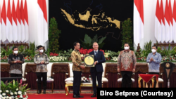 Presiden Jokowi menerima penghargaan atas pencapaian Indonesia dalam Swasembada Beras yang diserahkan oleh Dirjen IRRI Jean Balie di Istana Merdeka, Jakarta, Minggu (14/8). (Foto: Biro Setpres )