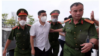 Bị cáo Phạm Anh Lê, áo trắng, đang được công an áp tải đến tòa án Hà Nội