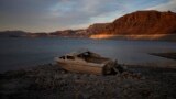 FILE - A formerly sunken boat sits high and dry along the shoreline of Lake Mead at the Lake Mead National Recreation Area, on May 10, 2022, near Boulder City, Nevada. (AP Photo/John Locher, File)