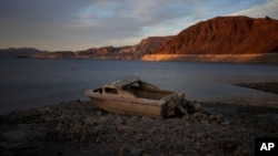 FILE - A formerly sunken boat sits high and dry along the shoreline of Lake Mead at the Lake Mead National Recreation Area, on May 10, 2022, near Boulder City, Nevada. (AP Photo/John Locher, File)