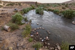 People bathe in the Jordan River near Kibbutz Karkom in northern Israel on Saturday, July 30, 2022. The river's decline is intertwined with the decades-old Arab-Israeli conflict and rivalries over precious water supplies in an area where so much is contested. (AP Photo/Oded Balilty)