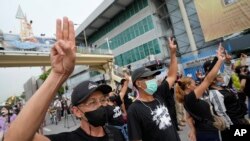 Anti-government protesters display the three-finger symbol of resistance during a protest in Bangkok, Aug. 24, 2022.