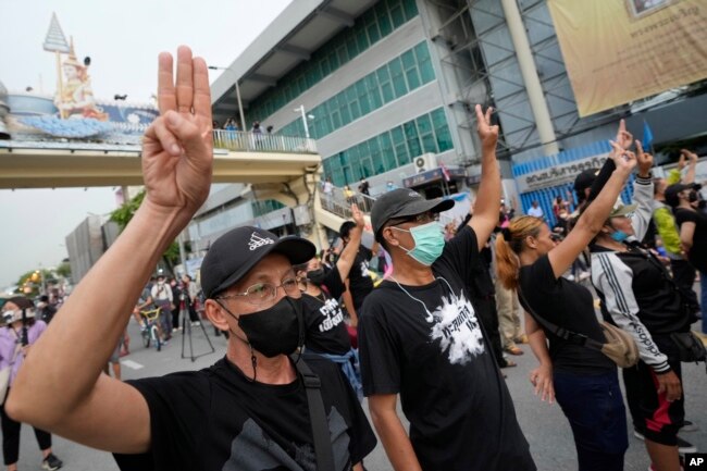 Anti-government protesters display the three-finger symbol of resistance during a protest in Bangkok, Aug. 24, 2022. (AP Photo/Sakchai Lalit)