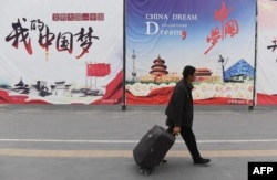资料照：一名男子走过北京街头张贴的中国梦宣传画。（2017年4月4日）