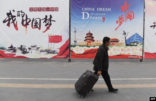 资料照：一名男子走过北京街头张贴的中国梦宣传画。（2017年4月4日）