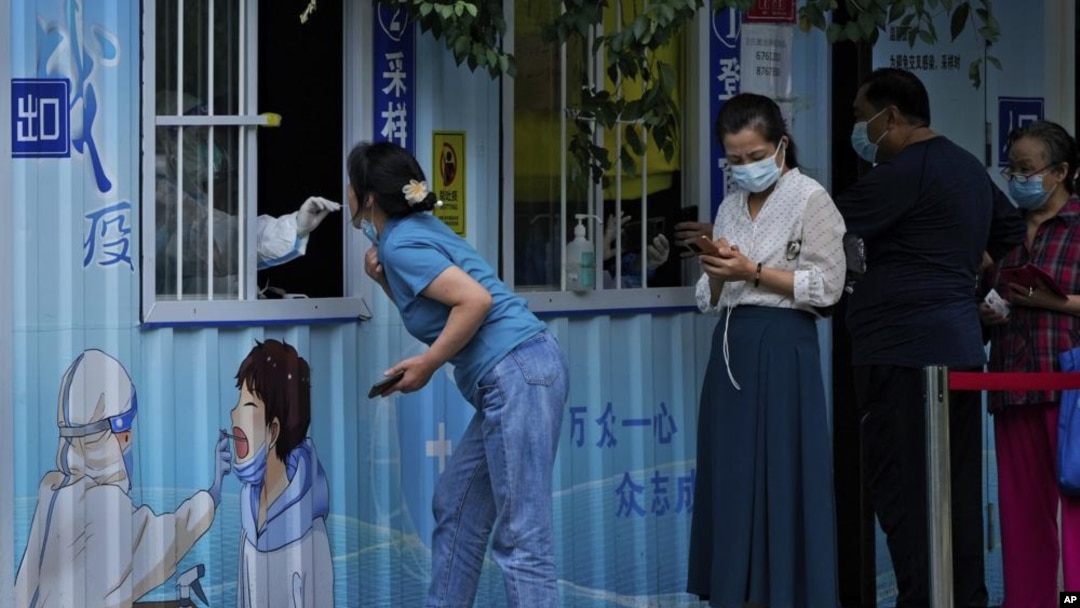 （2022年8月29日）北京居民在一條街道上接受日常新冠病毒咽拭子檢測。（美聯社照片）
