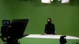 Masheed Barzz, seorang presenter untuk stasiun televisi 1TV, tambil dengan penutup wajah saat melakukan siaran di Kabul, Afghanistan, pada 25 Mei 2022. (Foto: AFP/Wakil Kohsar)