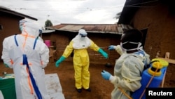  FILE - Kavota Mugisha Robert, a healthcare worker, decontaminates his colleague after he entered the house of 85-year-old woman, suspected of dying of Ebola, in the eastern Congolese town of Beni in the Democratic Republic of Congo, October 8, 2019. 