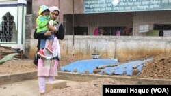 Monia Parvin and her son by the grave of her husband Nuruzzaman, Jony, a student wing leader of the opposition BNP party. According to witnesses, Jony was abducted by police from Dhaka on January 19, 2015. The next day his body was found. (Photo by Nazmul Haque for VOA)