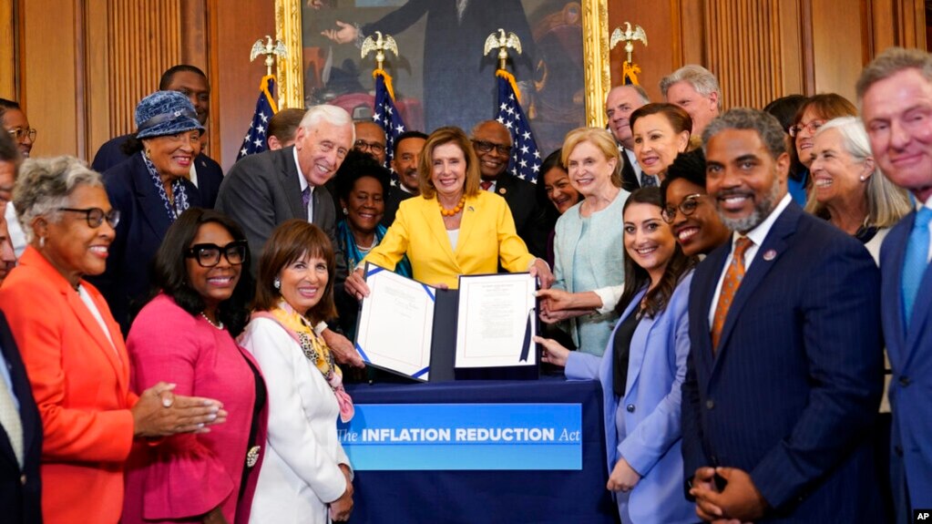 Chủ tịch Hạ viện Nancy Pelosi, với các nghị sĩ Đảng Dân chủ trong Hạ viện vây quanh, trưng ra Đạo luật Giảm lạm phát năm 2022 sau trong Điện Capitol ở Washington, ngày 12 tháng 8 năm 2022.