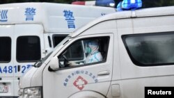 中國四川成都一名醫護人員身穿防護服駕駛救護車。（2020年12月9日）