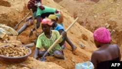 FILE - In this photograph taken on Apr. 4, 2018, gold miners dig at a mining site in the Cameroon town of Betare Oya.