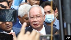 FILE - Former Malaysian Prime Minister Najib Razak, center, speaks to supporters outside at Court of Appeal in Putrajaya, Malaysia Tuesday, Aug. 23, 2022.